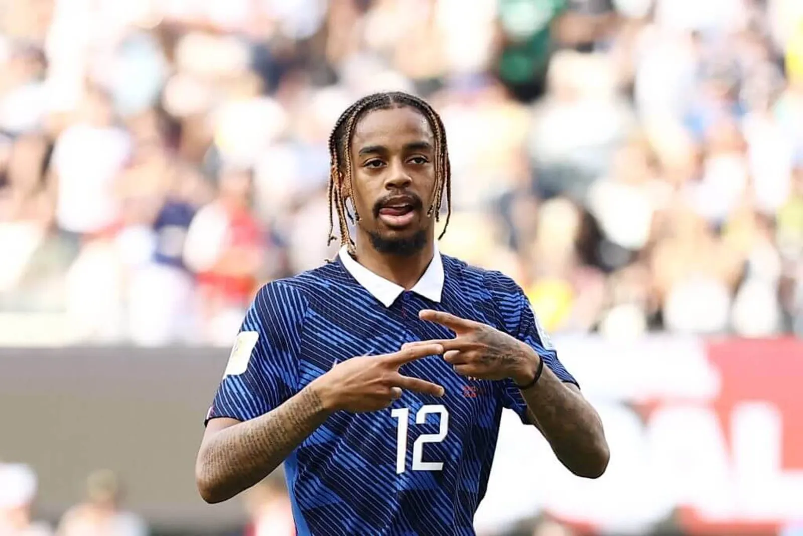 France's forward Bradley Barcola, wearing their blue home shirt, celebrates scoring a goal at the World Cup.
